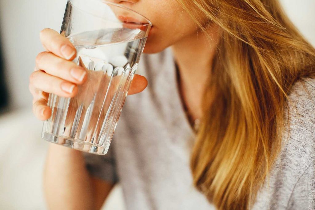 mujer bebiendo vaso de agua