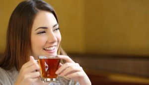 mujer sonriendo bebiendo té