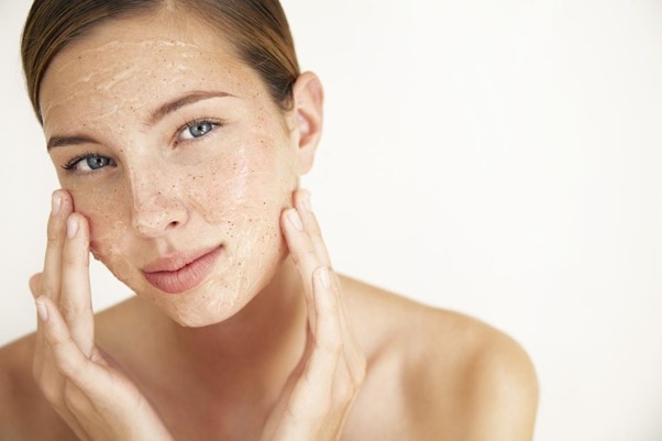 Mujer usando dermocosméticos en la cara