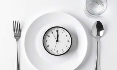 plato y cubiertos con un reloj representando el ayuno intermitente