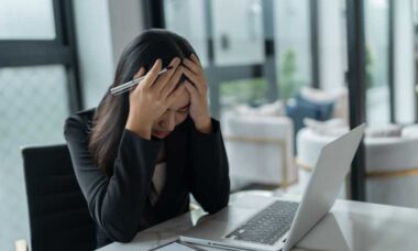 mujer en su oficina sufriendo de estrés laboral