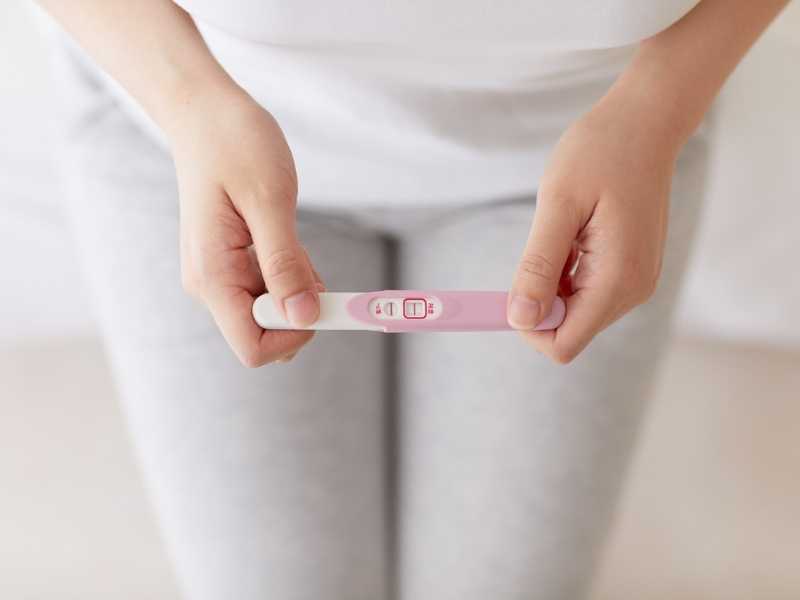 mujer sosteniendo una prueba de embarazo positiva
