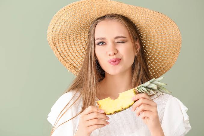 Mujer comiendo piña